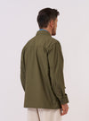 A model wears the Olive Recycled Polytech Jungle Jacket, shown from the back against a plain white background. The jacket's olive green color and utility-inspired design are prominent, highlighting the clean lines of the back panel and the structured shoulder construction. The model is standing in a studio setting.