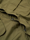 The Olive Recycled Polytech Jungle Jacket is shown in a detail view as a flat lay against a white background. This shot focuses on the upper section of the jacket, highlighting the structured collar, the top of the concealed button placket, and the two angled, pleated chest pockets with button-down flaps. The olive green fabric has a smooth, matte finish.
