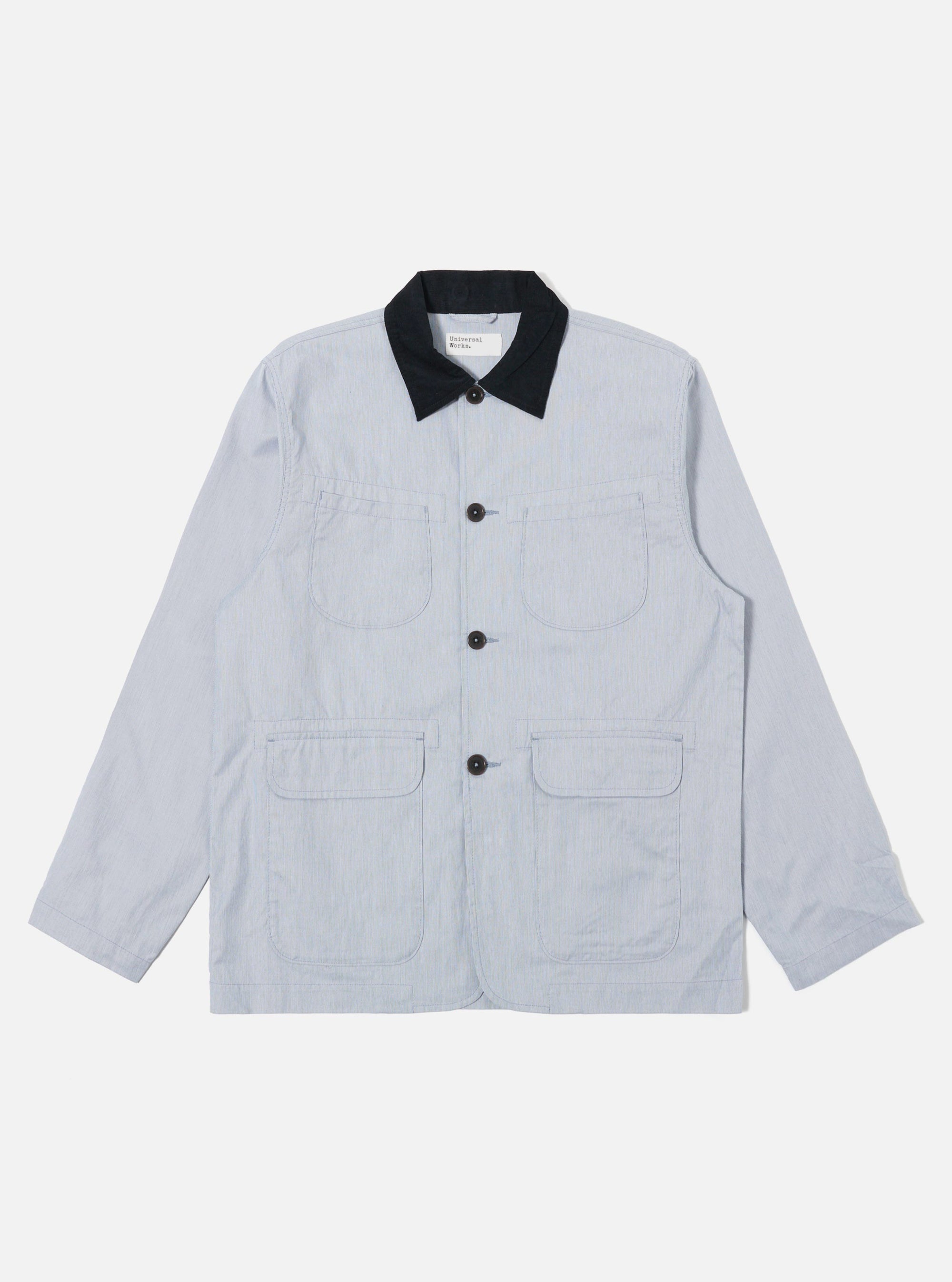 The Navy Kennedy Stripe Labour Jacket is shown as a flat lay against a plain white background. The jacket features a classic chore coat silhouette with a four-button front closure, a structured collar, and three large patch pockets on the front. The organic cotton fabric has a distinct vertical white stripe pattern on a dark navy base.