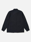 The Dark Navy Ospina Cotton Labour Jacket is shown from the back as a flat lay against a plain white background. The image highlights the clean, simple construction of the garment's rear panel, the straight hem, and the half-elasticated cuffs. The dark navy fabric features a visible seersucker texture.