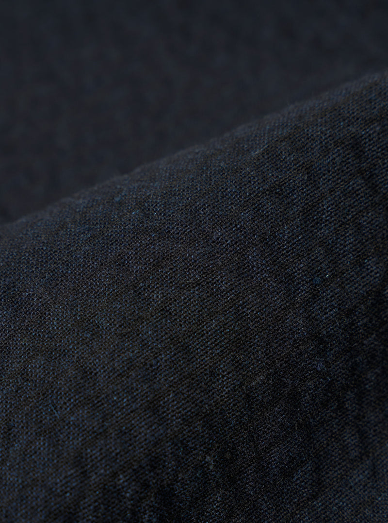 A close-up swatch image of the Dark Navy Ospina Cotton Labour Jacket fabric highlights the deep navy blue color and the distinct puckered texture of the seersucker material. The fabric fills the frame, providing a detailed view of the garment's weave and construction.