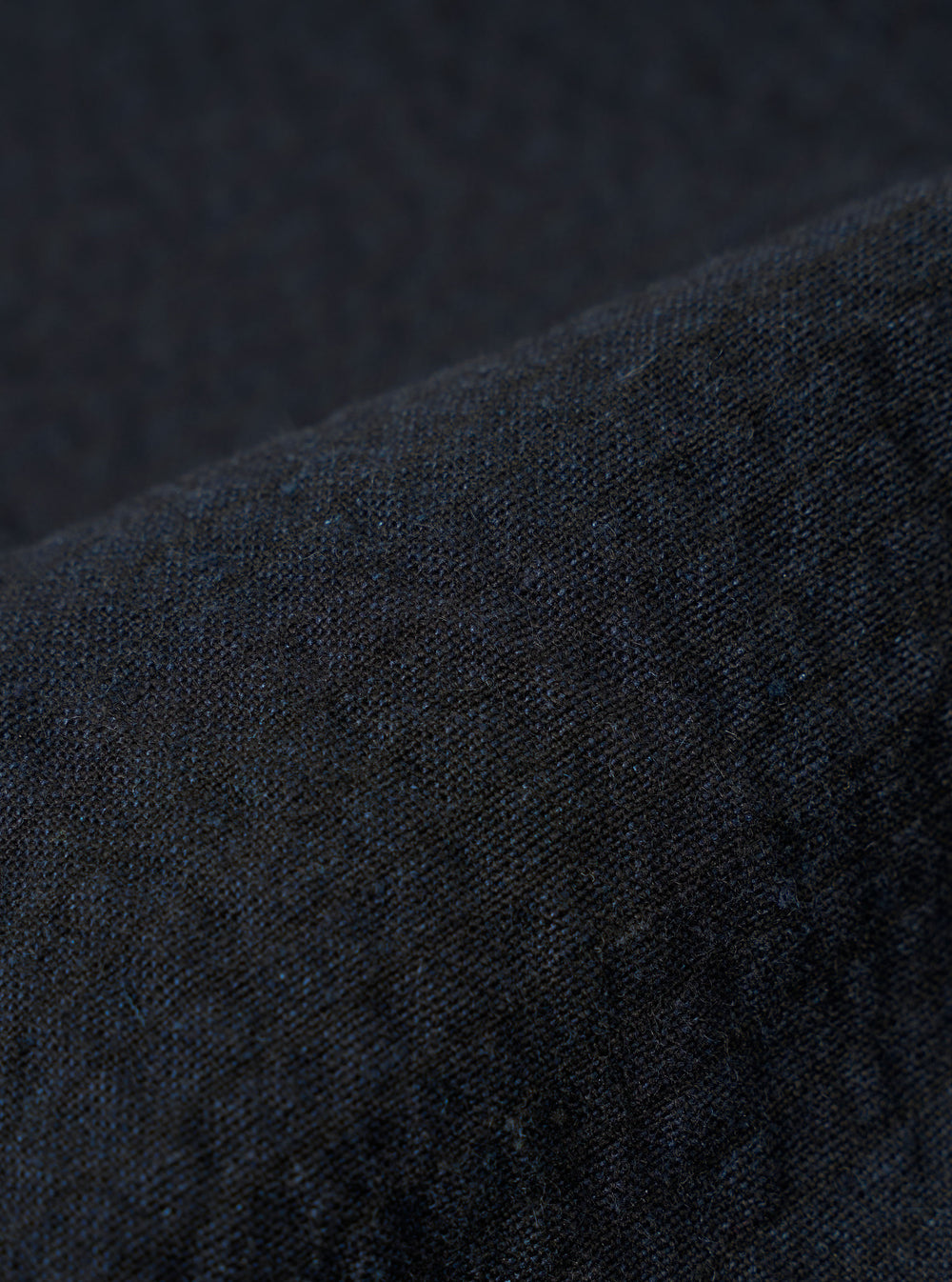 A close-up swatch image of the Dark Navy Ospina Cotton Labour Jacket fabric highlights the deep navy blue color and the distinct puckered texture of the seersucker material. The fabric fills the frame, providing a detailed view of the garment's weave and construction.