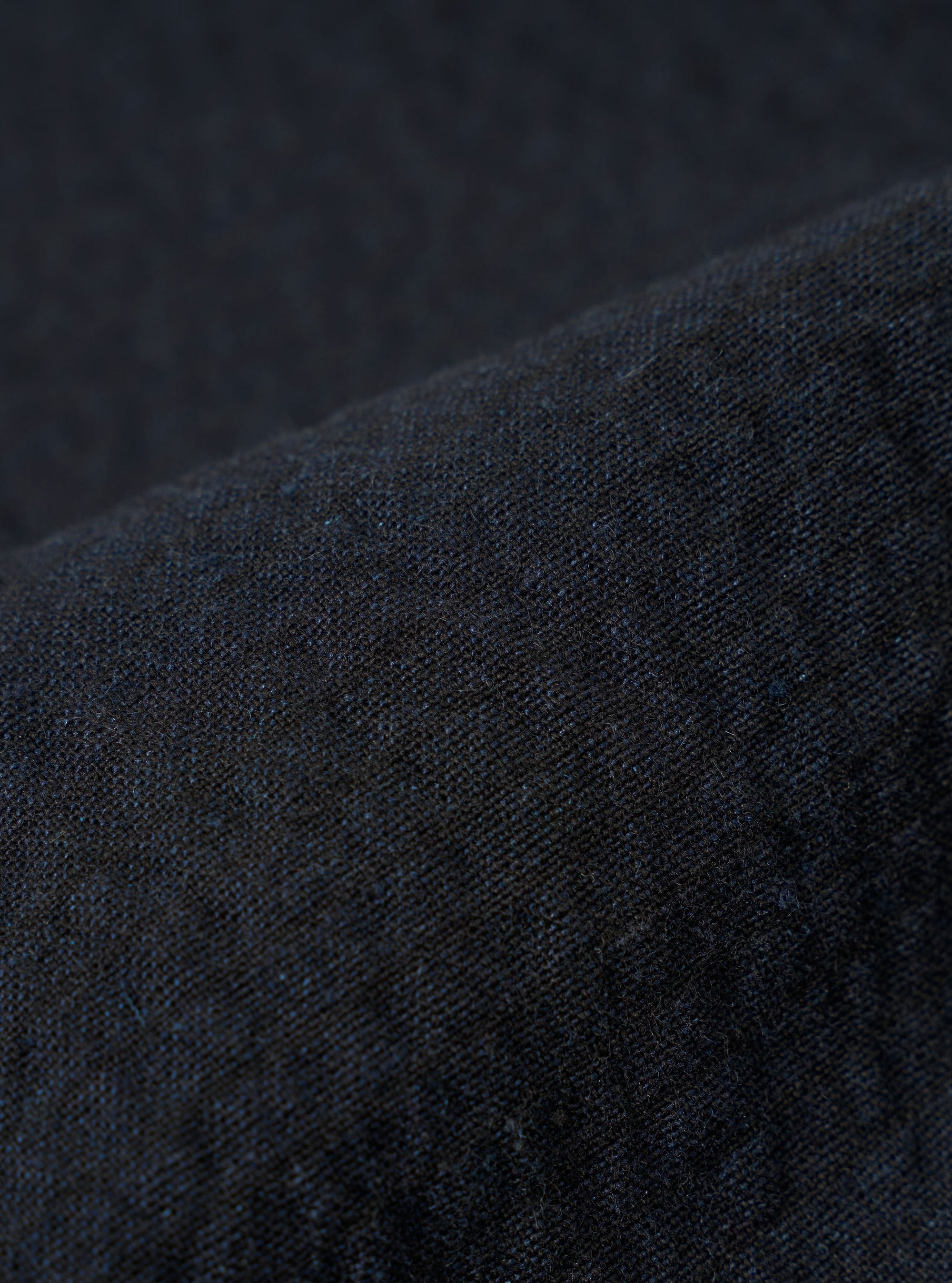 A close-up swatch image of the Dark Navy Ospina Cotton Labour Jacket fabric highlights the deep navy blue color and the distinct puckered texture of the seersucker material. The fabric fills the frame, providing a detailed view of the garment's weave and construction.