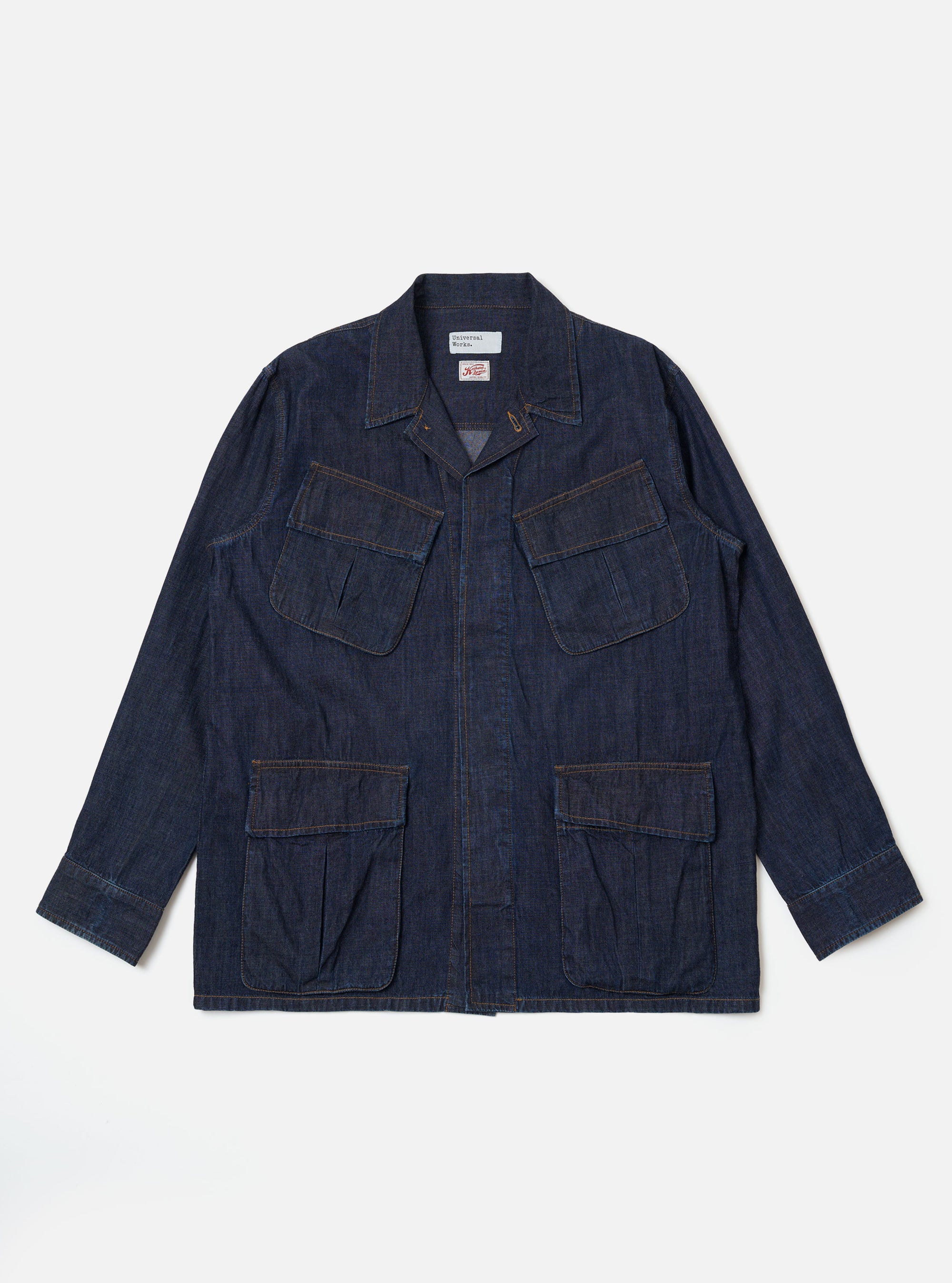 The Indigo Kaihara LT WT Denim Jungle Jacket is shown as a flat lay against a white background. The jacket features four large front patch pockets with flap closures, a central button-down front, and a structured collar. The garment is made from a dark indigo blue lightweight denim with visible stitching details throughout.