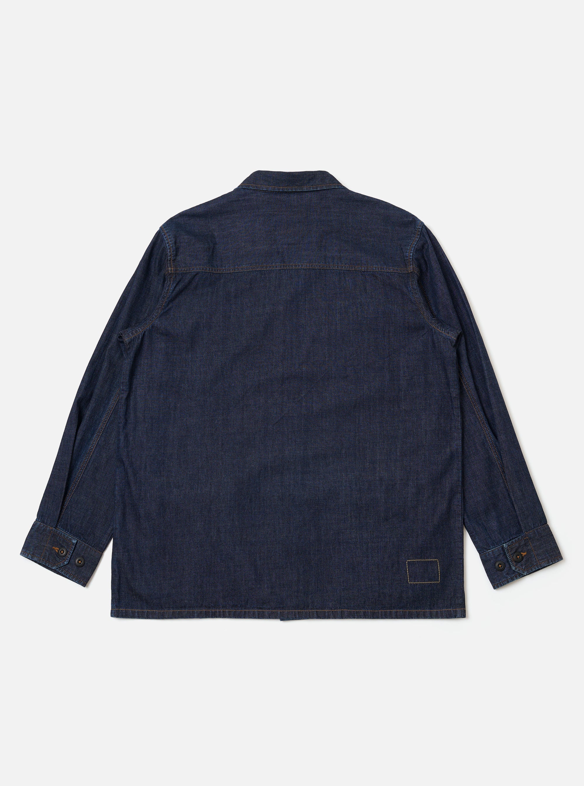 The Indigo Kaihara LT WT Denim Jungle Jacket is shown from the back as a flat lay against a plain white background. The image highlights the clean construction of the garment's rear, including a straight back yoke and a simple hem. The deep indigo blue denim fabric features visible stitching and a subtle textured grain.
