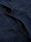 The Indigo Kaihara LT WT Denim Jungle Jacket is shown in a detail view as a flat lay against a plain white background. The image highlights the technical construction of the indigo-dyed cotton denim, focusing on the bottom of the concealed button placket and the two large, pleated, 3D bellowed pockets at the waist.