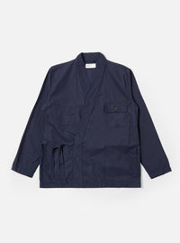 The Navy Peached Poplin Osaka Work Jacket is shown as a flat lay against a plain white background. The jacket features a wrap-front kimono-style design with a V-neckline and tie closures. It includes two large patch pockets at the waist and a single chest pocket. The navy blue cotton fabric has a smooth, matte finish.