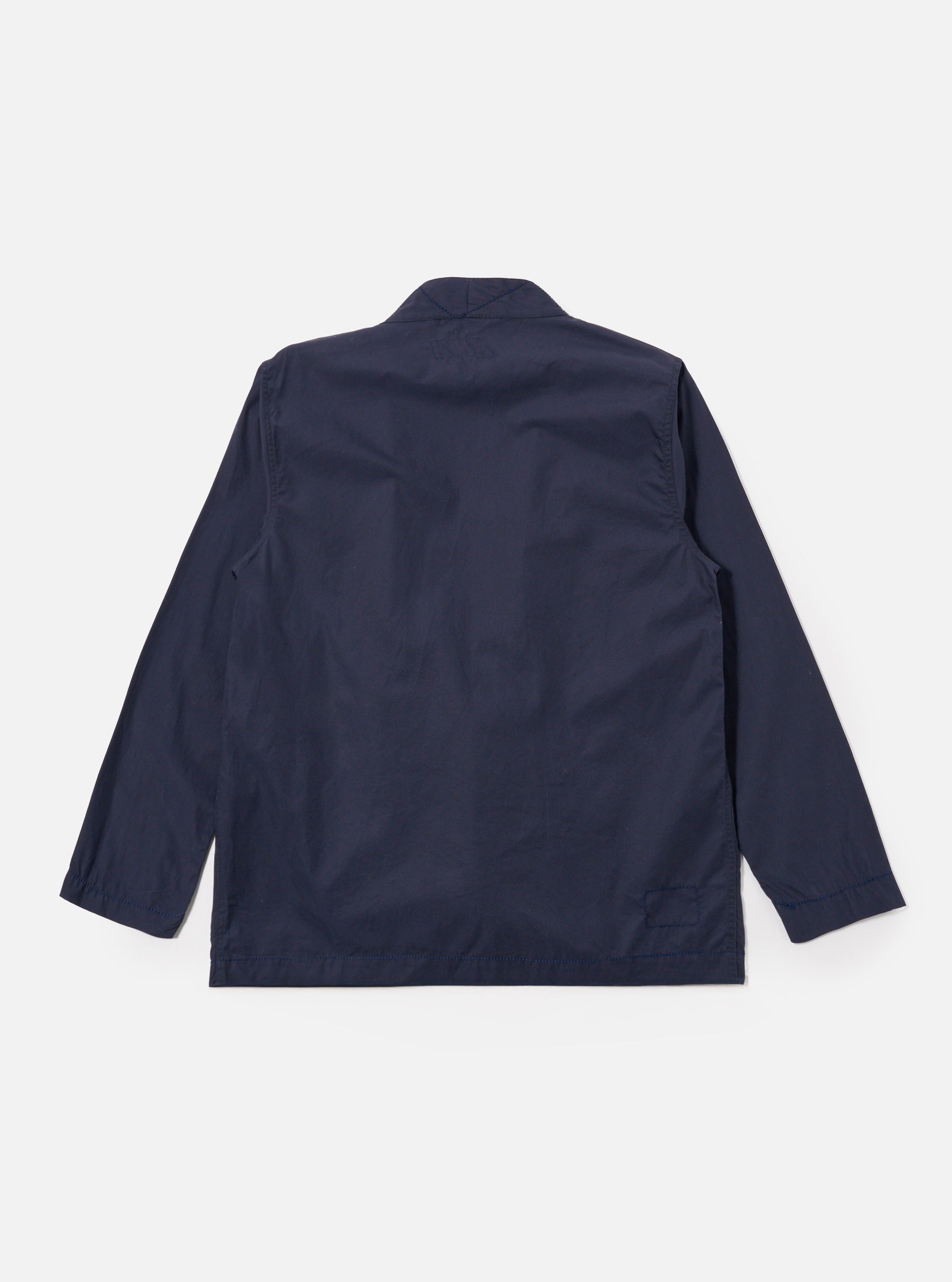 The Navy Peached Poplin Osaka Work Jacket is shown from the back as a flat lay against a plain white background. The image highlights the smooth texture of the navy blue cotton poplin fabric, a straight hem, and the simple construction of the garment's rear panel.