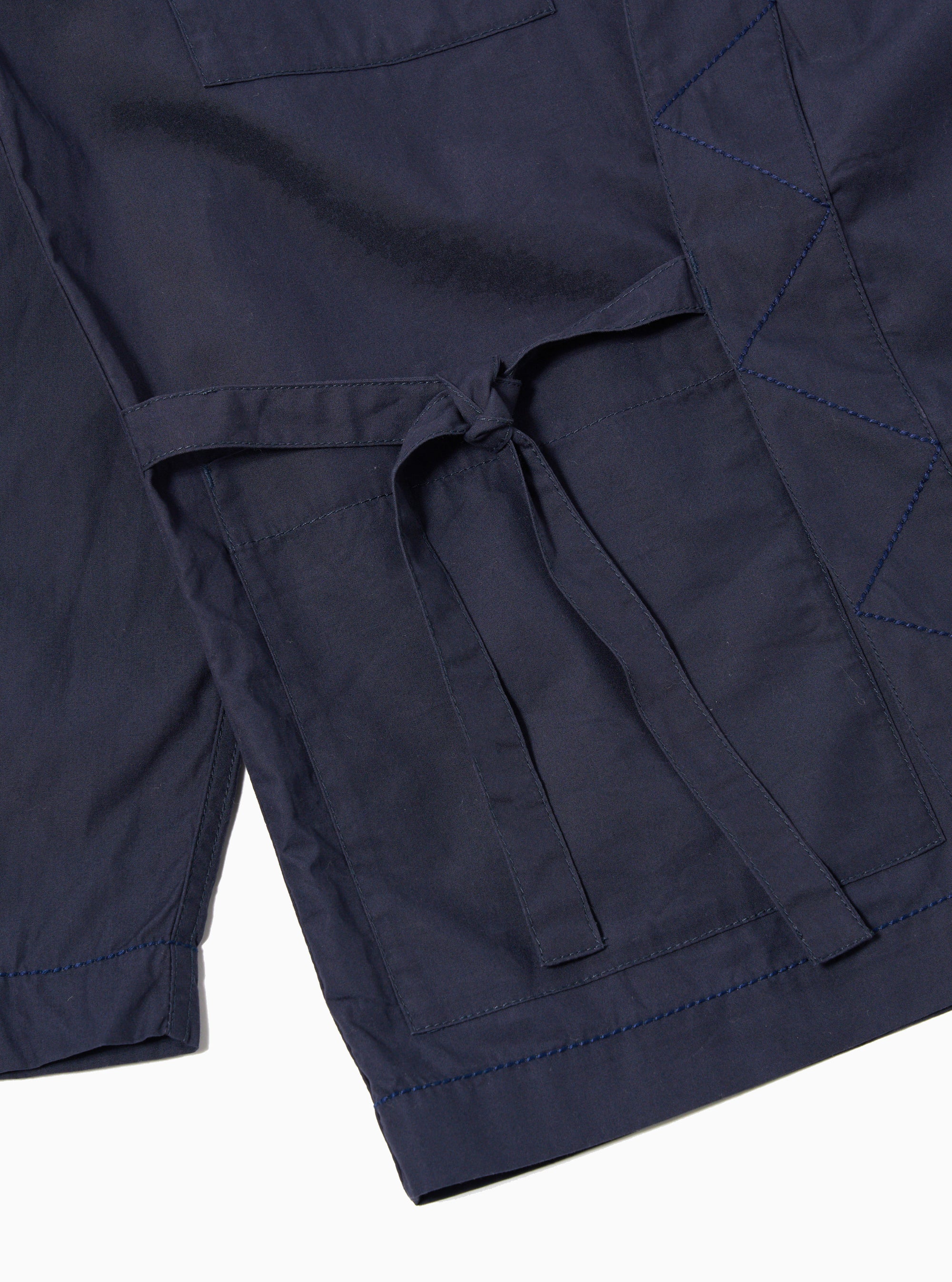 The Navy Peached Poplin Osaka Work Jacket is shown from the back as a flat lay against a plain white background. The image highlights the clean construction of the garment's rear, the wrap-style collar, and the smooth texture of the navy blue peached poplin fabric.