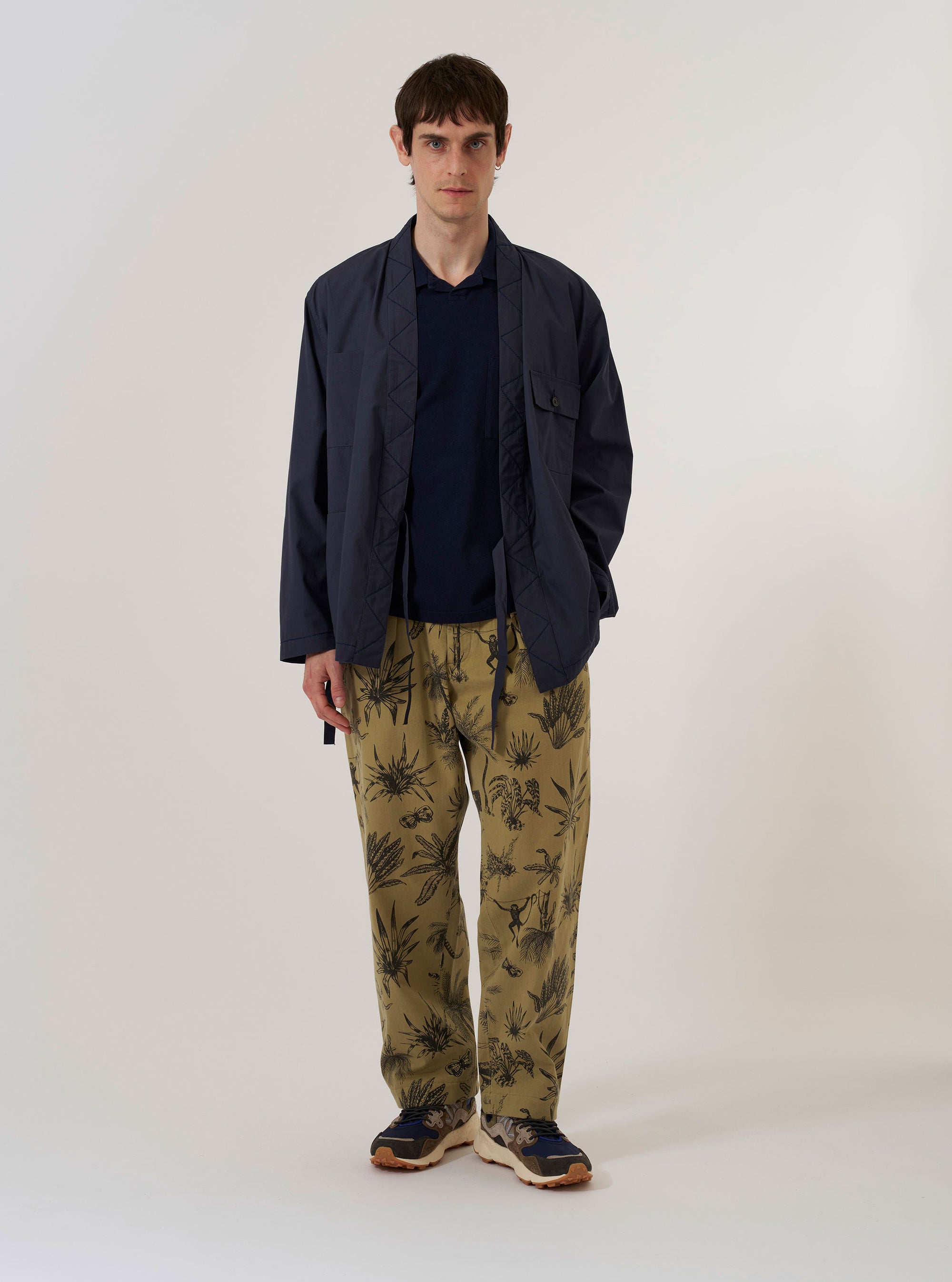 The Navy Peached Poplin Osaka Work Jacket is shown as a flat lay against a plain white background. The jacket features a kimono-style wrap front with internal and external tie closures, two chest patch pockets, and two lower patch pockets. The design includes visible contrast stitching throughout the navy blue peached poplin fabric.