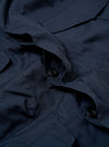 The Navy Recycled Polytech Parachute Field Jacket is shown from the back as a flat lay against a plain white background. The image highlights the clean construction of the jacket's rear, featuring adjustable button tabs at the waist and a straight hem. The smooth, dark navy recycled polytech fabric is visible throughout.