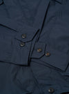 The Navy Recycled Polytech Parachute Field Jacket is shown from a rear angle as a flat lay against a plain white background. The image highlights the jacket's smooth navy blue fabric, a straight hem with an adjustable drawcord, and a contrasting brown corduroy collar.