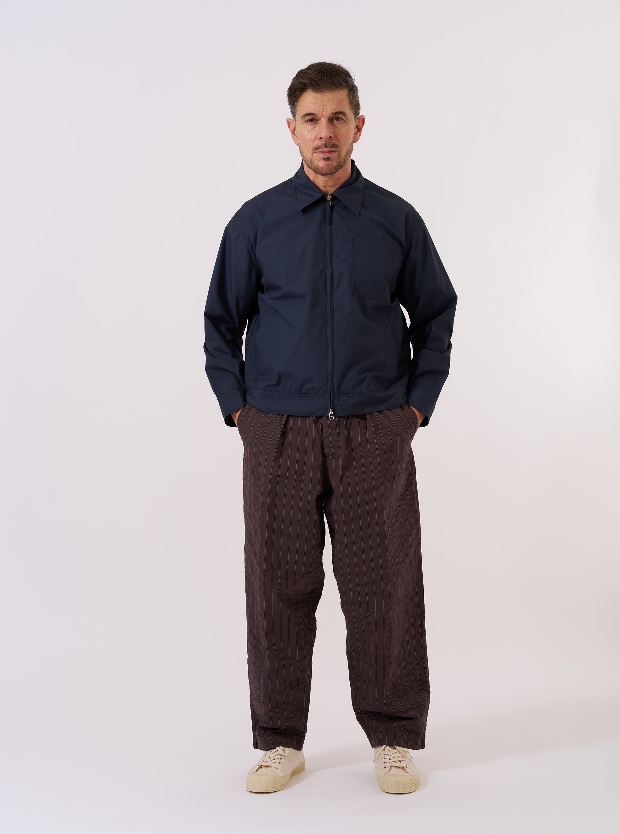 The Navy Recycled Polytech Rose Bowl Jacket is shown as a flat lay against a plain white background. The jacket features a full-length silver zip front, a slightly oversized collar, two slanted welt pockets, and a large patch pocket on the left chest. The dark navy fabric has a smooth, matte finish.