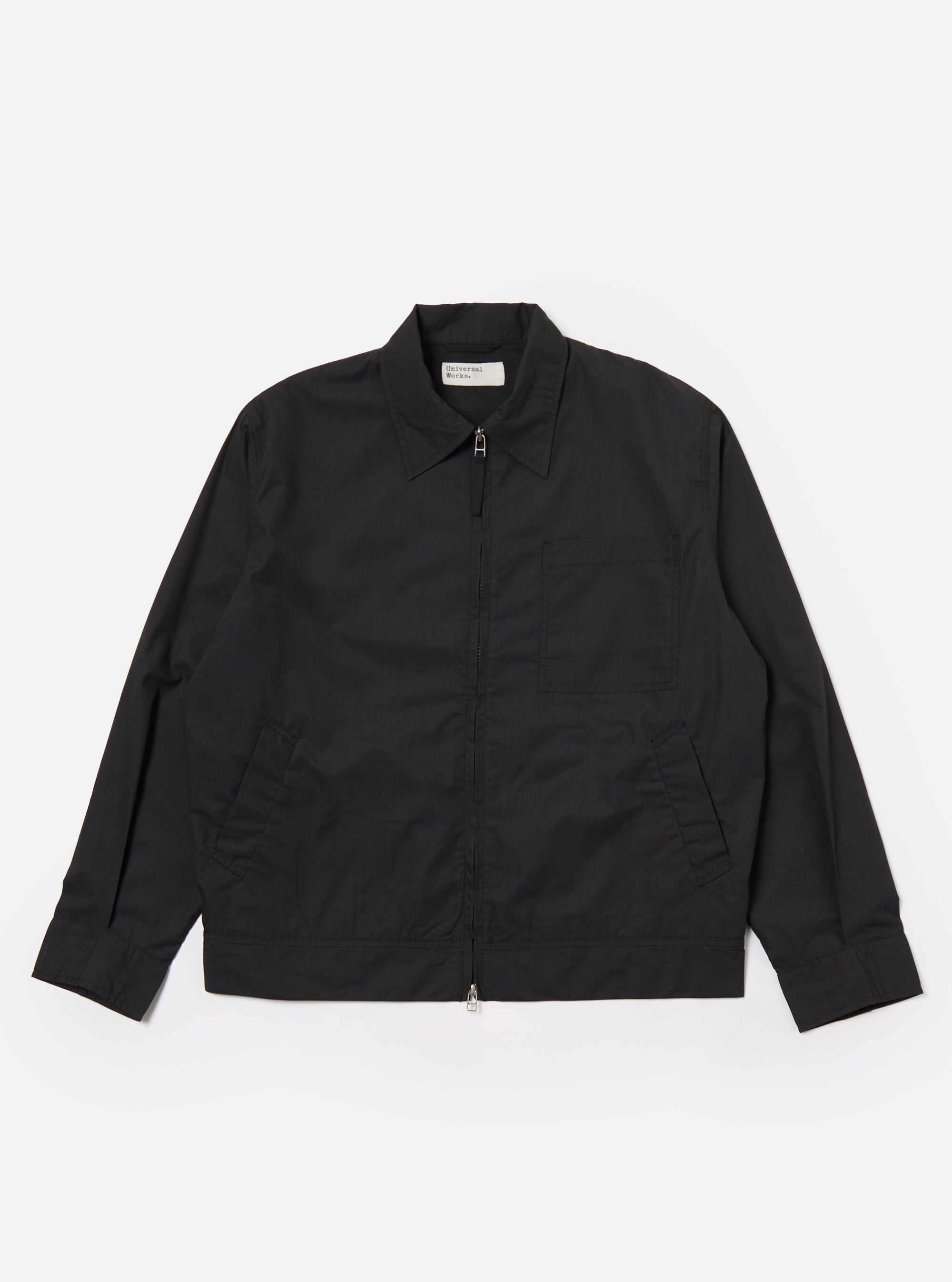 The Black Recycled Polytech Rose Bowl Jacket is shown as a flat lay against a white background. The jacket features a boxy silhouette, a zip-front closure, and an oversized collar. It has one large patch pocket on the chest and two welt pockets at the waist. The fabric is a smooth, black recycled polytech material.