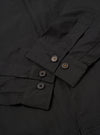 The Black Recycled Polytech Rose Bowl Jacket is shown from the back as a flat lay against a plain white background. The image highlights the jacket's simple construction, featuring a straight hem with adjustable button tabs on either side and vertical pleats extending from the shoulder yoke to the hem.
