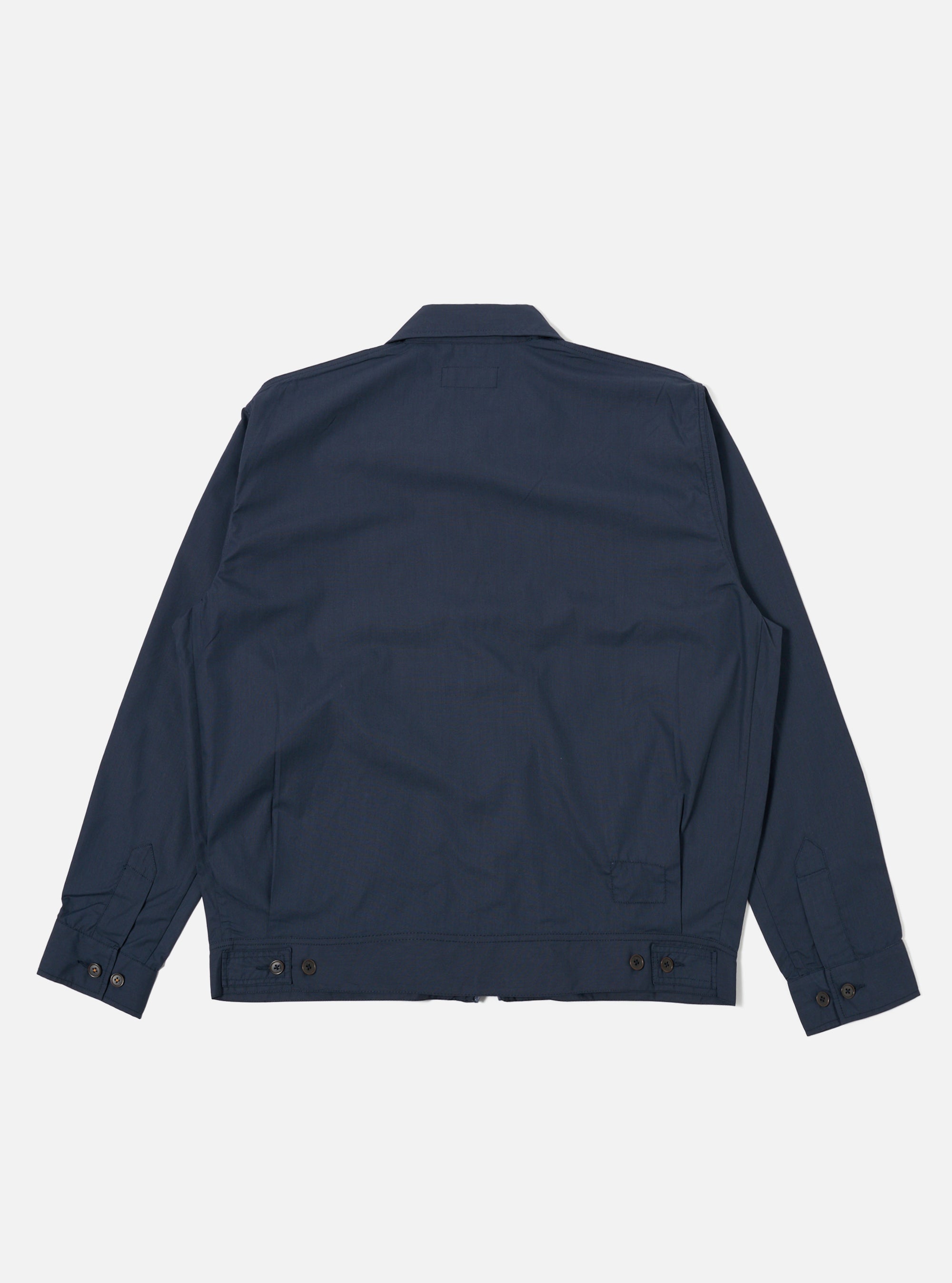 The Navy Recycled Polytech Rose Bowl Jacket is shown from the back as a flat lay against a plain white background. The image highlights the jacket's smooth, dark navy fabric, a straight hem with adjustable button tabs, and pleats at the back of the shoulders and cuffs.