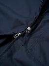 The Navy Recycled Polytech Rose Bowl Jacket is shown from a rear angle as a flat lay against a plain white background. The image highlights the jacket's boxy fit, smooth navy fabric, and adjustable back hem with button detailing.