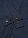 The Navy Recycled Polytech Rose Bowl Jacket is shown from the back as a flat lay against a plain white background. The image highlights the jacket's smooth navy blue fabric, a central vertical seam, and an adjustable back hem with a buttoned tab. The pleated details on the rear of the sleeves are also visible.