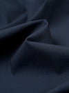 The Navy Recycled Polytech Rose Bowl Jacket is shown as a flat lay against a white background. The image provides a detailed view of the jacket's back, highlighting the clean construction, simple hem, and the smooth, technical texture of the dark navy recycled polytech fabric.
