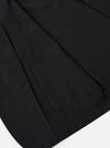 The Black Tropical Suiting Two Button Jacket is shown in a detail view as a flat lay against a plain white background. The image highlights the smooth texture of the black wool-blend fabric, focusing on the two-button front closure and the structured lapels.