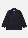 The Navy Tropical Suiting Two Button Jacket is shown as a flat lay against a white background. The jacket features a two-button front closure, a notched lapel with pick-stitching, and three front pockets, including two large patch pockets at the waist and one at the chest. The fabric is a smooth, lightweight navy tropical suiting material.