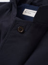 The Navy Tropical Suiting Two Button Jacket is shown from the back as a flat lay against a plain white background. The image highlights the clean, unstructured silhouette of the rear panel, the two-piece sleeves, and the smooth texture of the navy blue tropical suiting fabric.