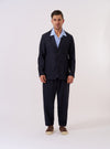 The Navy Tropical Suiting Two Button Jacket is displayed as a flat lay against a plain white background. The jacket features a relaxed fit with a two-button front closure, a wide notch lapel, and three front patch pockets, including one at the chest and two at the waist. The navy blue fabric is a lightweight tropical wool blend with a smooth, refined texture.