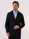A model wears the Black Tropical Suiting Two Button Jacket over a light-colored shirt against a plain white background. The jacket features a classic two-button front closure, notched lapels, and a structured silhouette. The garment is made from a smooth, black fabric.