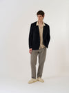 The Black Organic Fine Cord Two Button Jacket is shown as a flat lay against a plain white background. The jacket features a two-button front closure, classic notched lapels, and three patch pockets: one at the chest and two at the waist. The fine-wale corduroy texture of the black organic cotton fabric is visible across the garment.