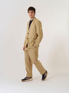 The Sand Organic Fine Cord Two Button Jacket is presented as a flat lay against a plain white background. The jacket features notched lapels, a two-button front closure, and two large patch pockets at the waist. The fine-wale corduroy texture of the sand-colored organic cotton fabric is clearly visible.