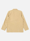 The Sand Organic Fine Cord Two Button Jacket is shown from the back as a flat lay against a plain white background. The image highlights the clean, simple construction of the jacket's rear, featuring a central vertical seam and a straight hem. The fine corduroy texture of the sand-colored organic cotton is visible.