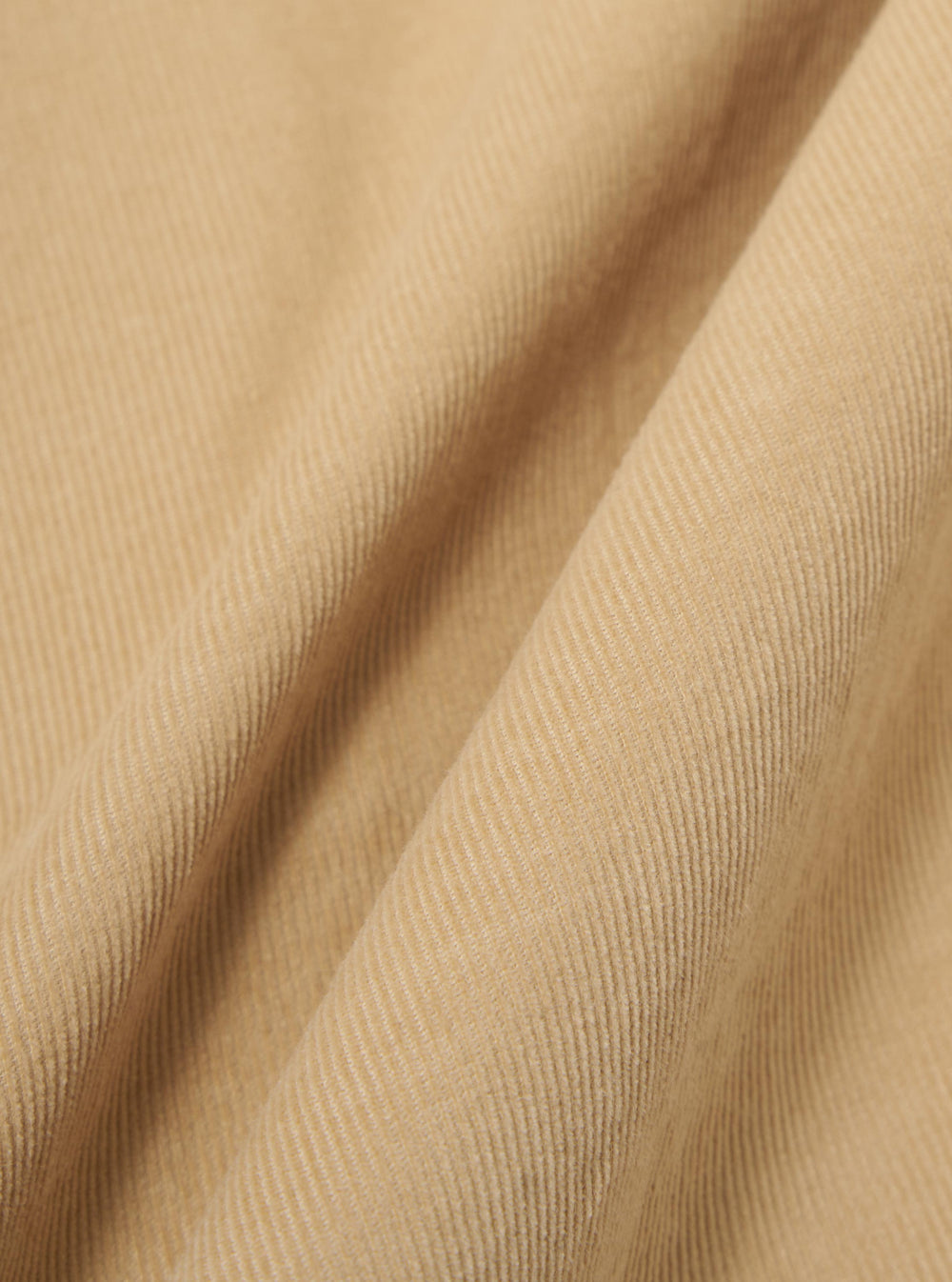A close-up swatch image of the Sand Organic Fine Cord Two Button Jacket fabric displays a light sand-colored organic cotton with a distinct fine-wale corduroy texture. The vertical ridges of the corduroy material are clearly visible, filling the entire frame.