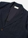 The Dark Navy Ospina Cotton Two Button Jacket is shown from a rear three-quarter angle as a flat lay against a plain white background. The image highlights the jacket's structured back with a central vertical seam, two-piece sleeve construction, and a straight hem. The dark navy fabric features a visible puckered seersucker texture.