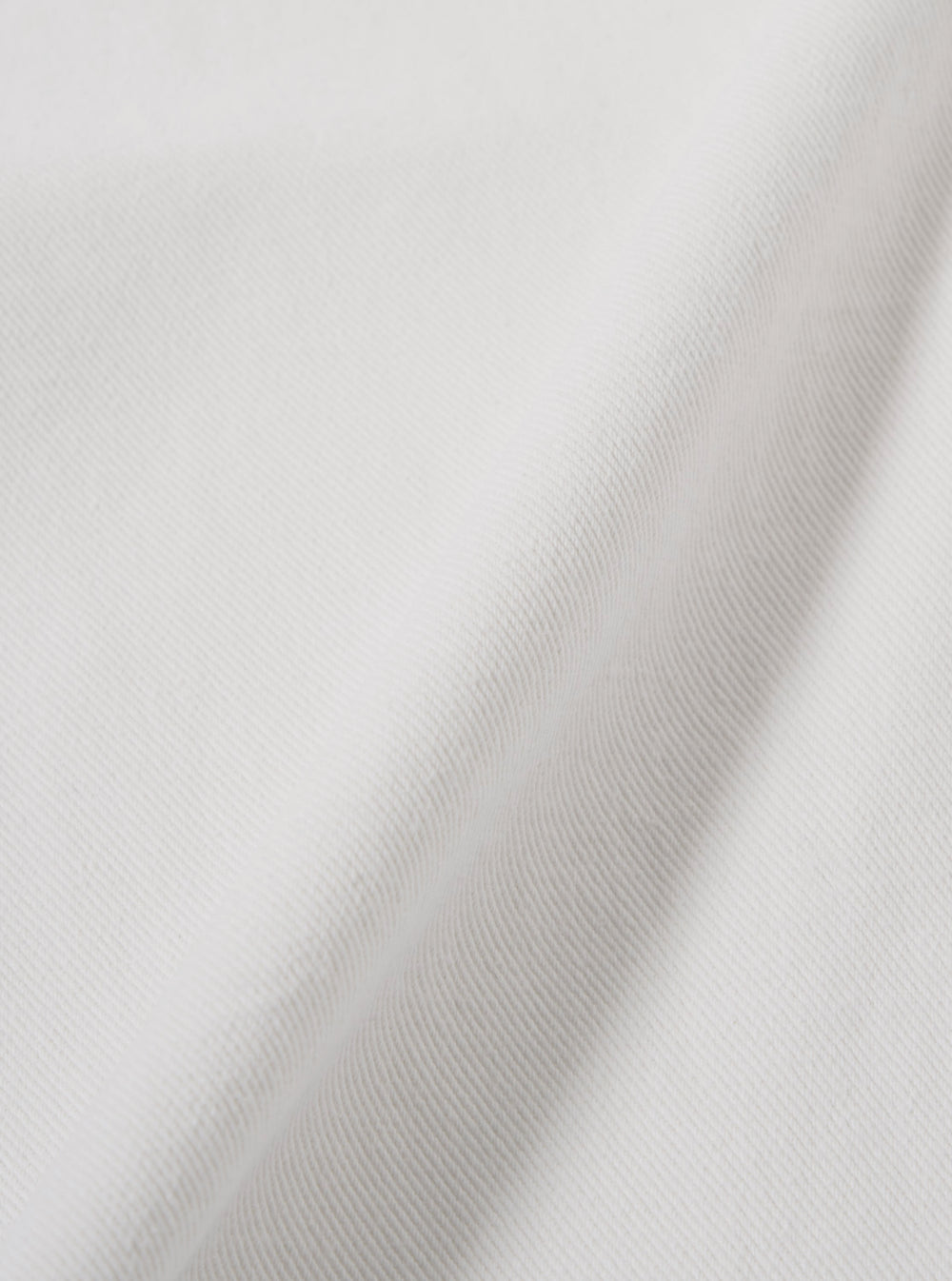 A close-up fabric swatch of the Ecru Slub Drill Duke Pant highlights the off-white color and textured weave of the slub drill cotton. The image focuses on the textile detail, showing the irregular thickness of the yarns and the durable nature of the fabric. No model or mannequin is present.