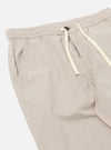 The Brown Kennedy Stripe Hi Water Trouser is shown from the back as a flat lay against a plain white background. The trousers feature a vertical brown stripe pattern and a cropped length. The image highlights the elasticated waistband with a drawstring closure and the slim construction of the rear.