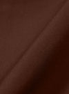 A close-up fabric swatch of the Brown Peached Poplin Judo Pant is shown, highlighting the warm, earthy brown color and the smooth, tightly woven texture of the cotton poplin fabric. The lightly brushed, peached finish is visible across the material.