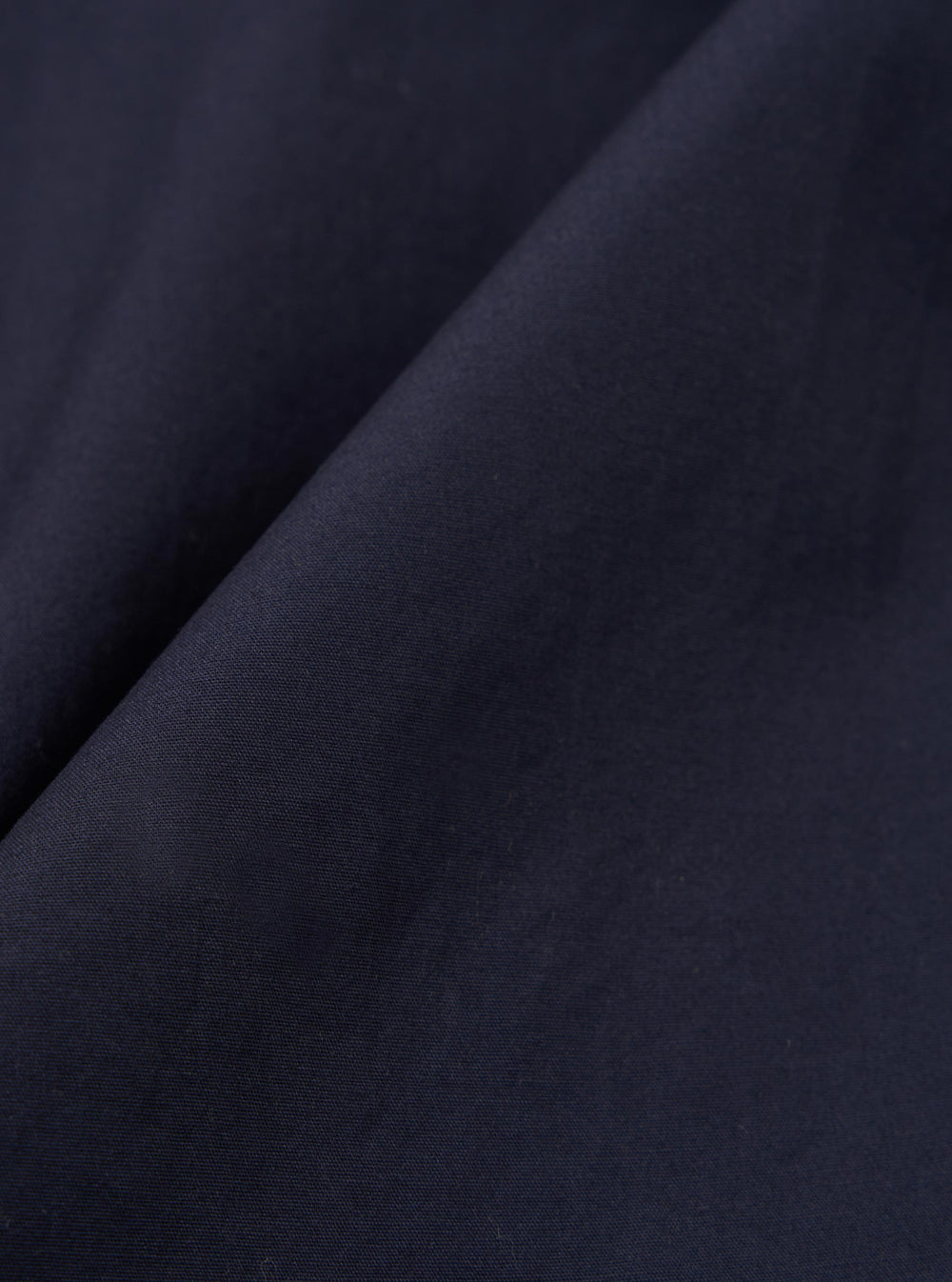 A close-up swatch image of the Navy Peached Poplin Judo Pant fabric displays a deep navy blue color with a smooth, matte finish. The fine, dense weave of the cotton poplin material is clearly visible, highlighting the peached texture.