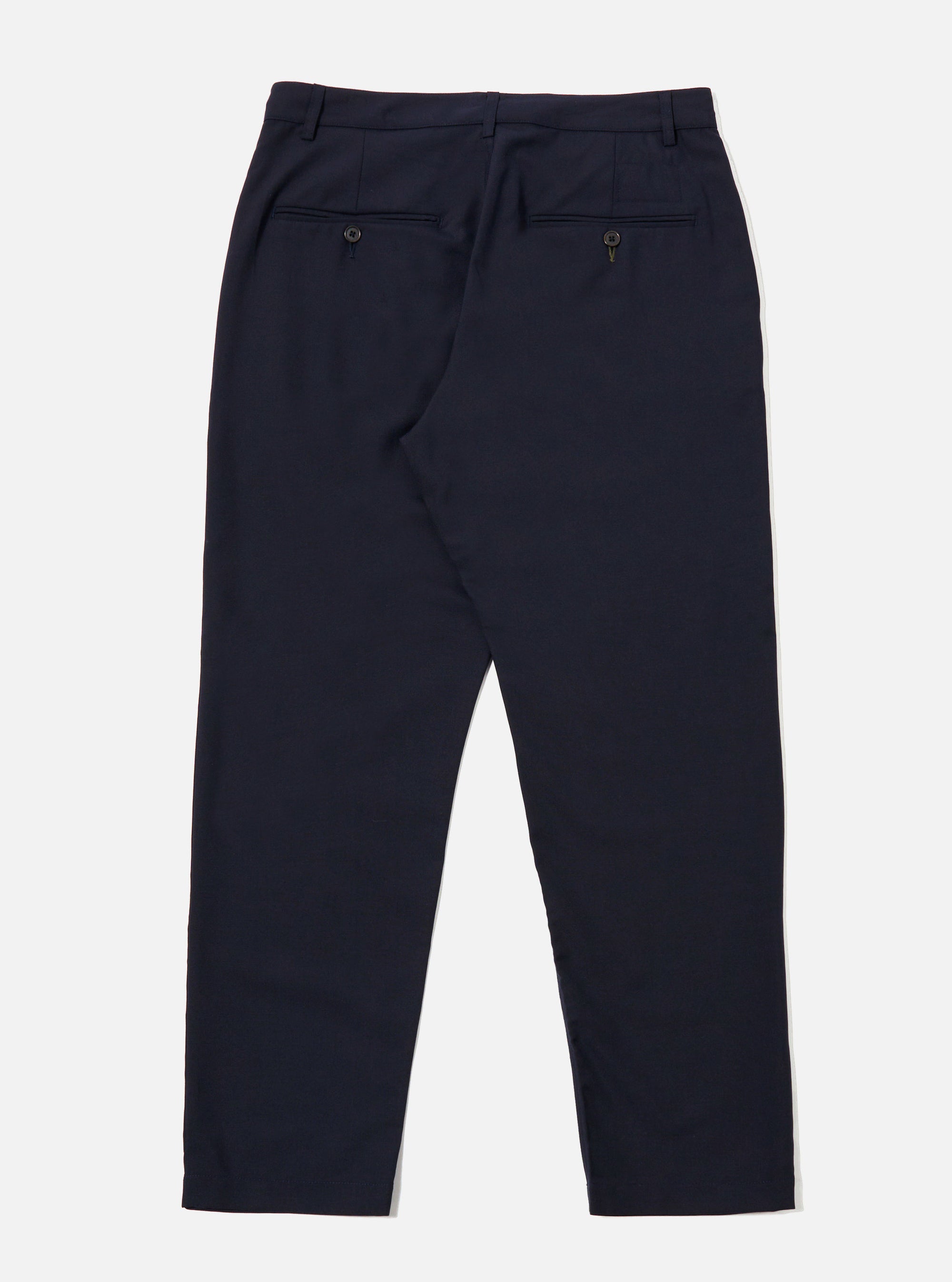The Navy Tropical Suiting Military Chino is shown from a rear angle as a flat lay against a plain white background. The image highlights the two rear jetted pockets with button closures and the clean construction of the seat. The dark navy fabric, made from a polyester and wool blend, appears smooth and lightweight.
