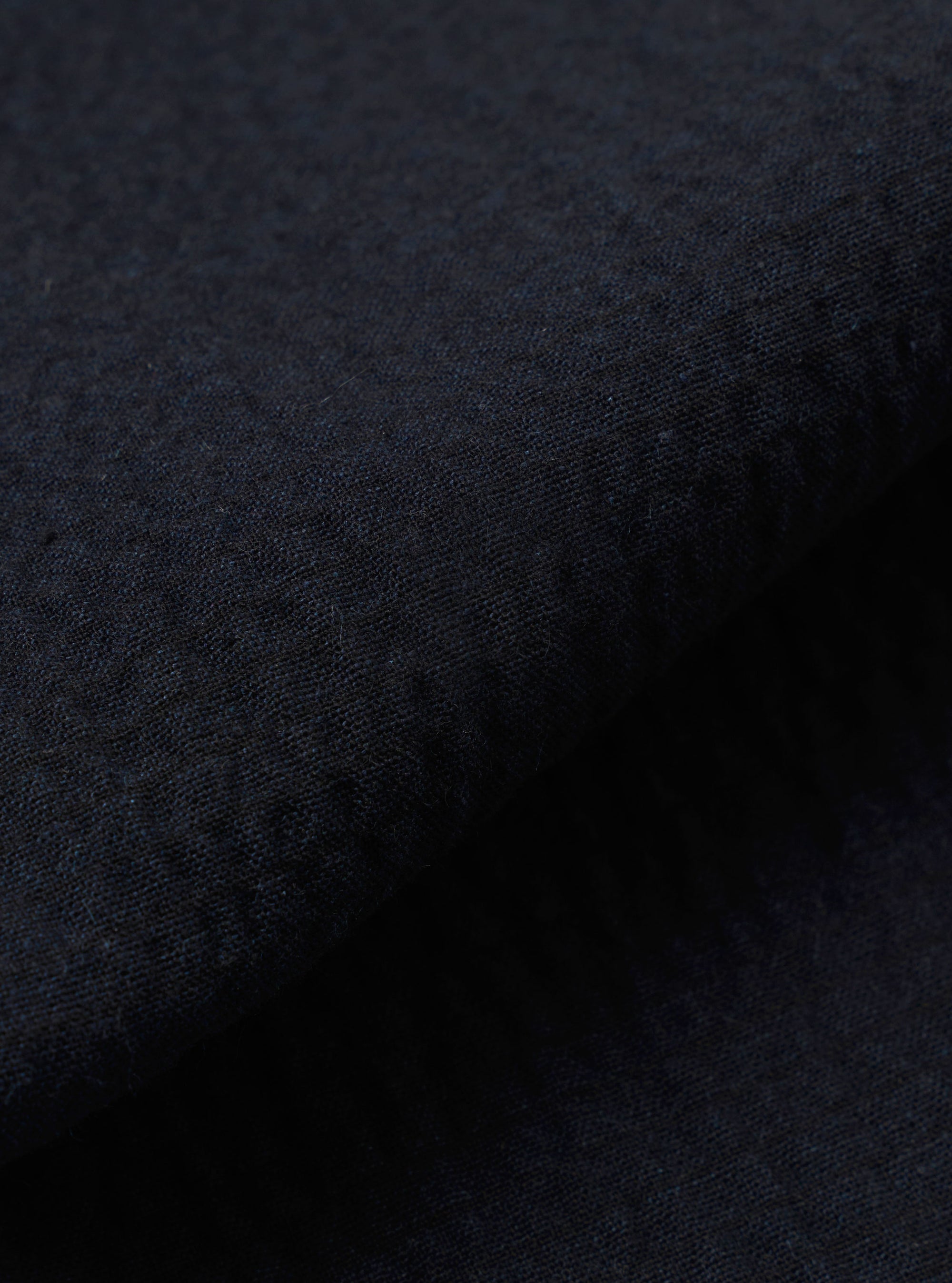 A close-up fabric swatch of the Dark Navy Ospina Cotton Military Chino is shown, highlighting the deep navy blue color and the distinct puckered texture of the seersucker fabric.