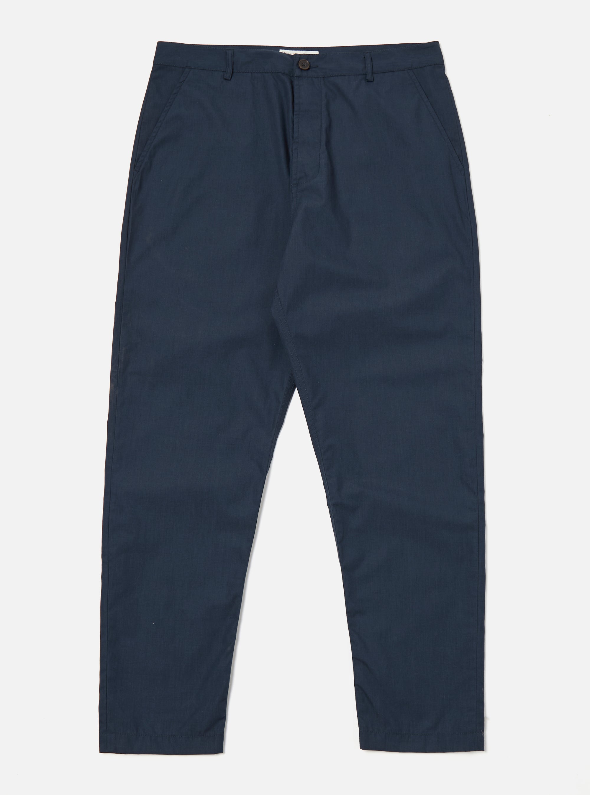 The Navy Recycled Polytech Military Chino is shown as a flat lay against a plain white background. The trousers feature a button closure at the waist, a central zip fly, and two slanted front pockets. The dark navy fabric has a smooth, technical finish, and the garment is cut with a slight taper toward the hem.
