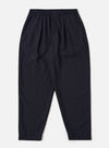 The Navy Tropical Suiting Pleated Track Pant is shown as a flat lay against a plain white background. The trousers feature an elasticated waistband with a tonal drawstring, a single pleat at the front of each leg, and a tapered silhouette. The fabric is a smooth, lightweight navy blue tropical suiting.