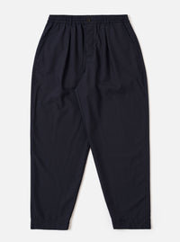 The Navy Tropical Suiting Pleated Track Pant is shown as a flat lay against a plain white background. The trousers feature an elasticated waistband with a tonal drawstring, a single pleat at the front of each leg, and a tapered silhouette. The fabric is a smooth, lightweight navy blue tropical suiting.