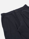 The Dark Navy Ospina Cotton Oxford Pant is shown from the back as a flat lay against a plain white background. The image highlights the two rear pockets, one with a buttoned flap and one with a buttoned jet, as well as the elasticated waistband. The dark navy fabric features a subtle, puckered seersucker texture.