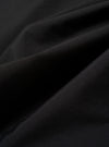 The Black Recycled Polytech Pleated Track Pant is shown in a close-up detail shot against a plain white background. The image focuses on the rear of the garment, highlighting the clean construction of the elasticated waistband and a single rear patch pocket. The black recycled polytech fabric has a smooth, technical finish with visible tonal stitching.