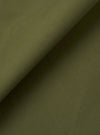 A close-up fabric swatch of the Olive Recycled Polytech Pleated Track Pant highlights the smooth, compact weave of the olive green material. The technical fabric, a blend of recycled polyester and cotton, is shown in detail to emphasize its uniform color and clean, utilitarian texture.