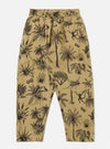 The Sand Jungle Toile Twill Oxford Pant is displayed as a flat lay against a plain white background. The trousers feature an all-over intricate jungle toile print in a dark shade over a sand-colored base. They are designed with a wide-leg silhouette, a pleated front, and an elasticated waistband with a drawstring.