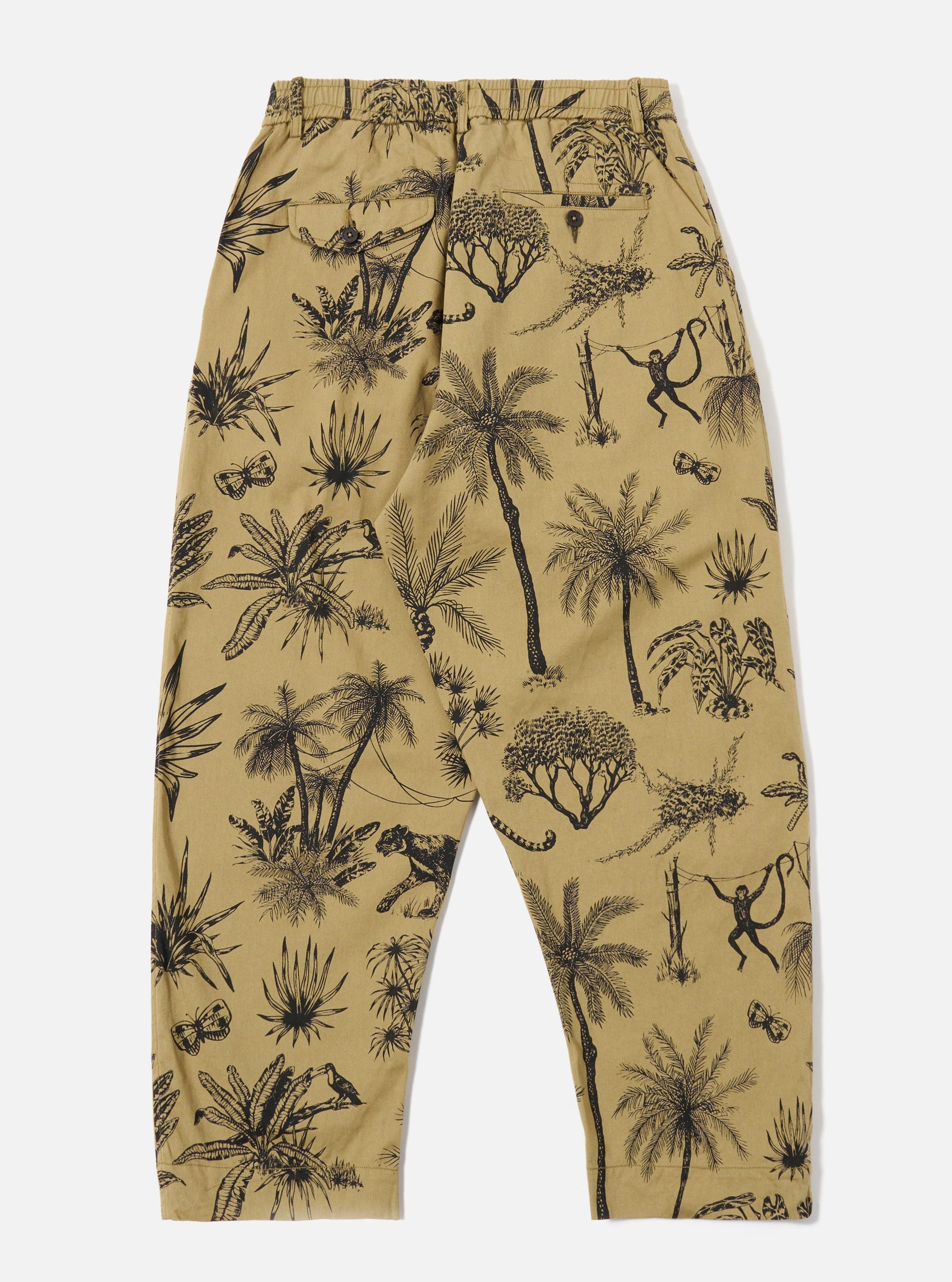 The Sand Jungle Toile Twill Oxford Pant is shown from the back as a flat lay against a plain white background. The trousers feature an all-over dark jungle toile print on a sand-colored base, with a single rear patch pocket on the right side and an elasticated waistband. The wide-leg silhouette is visible, showcasing the textured cotton twill fabric.