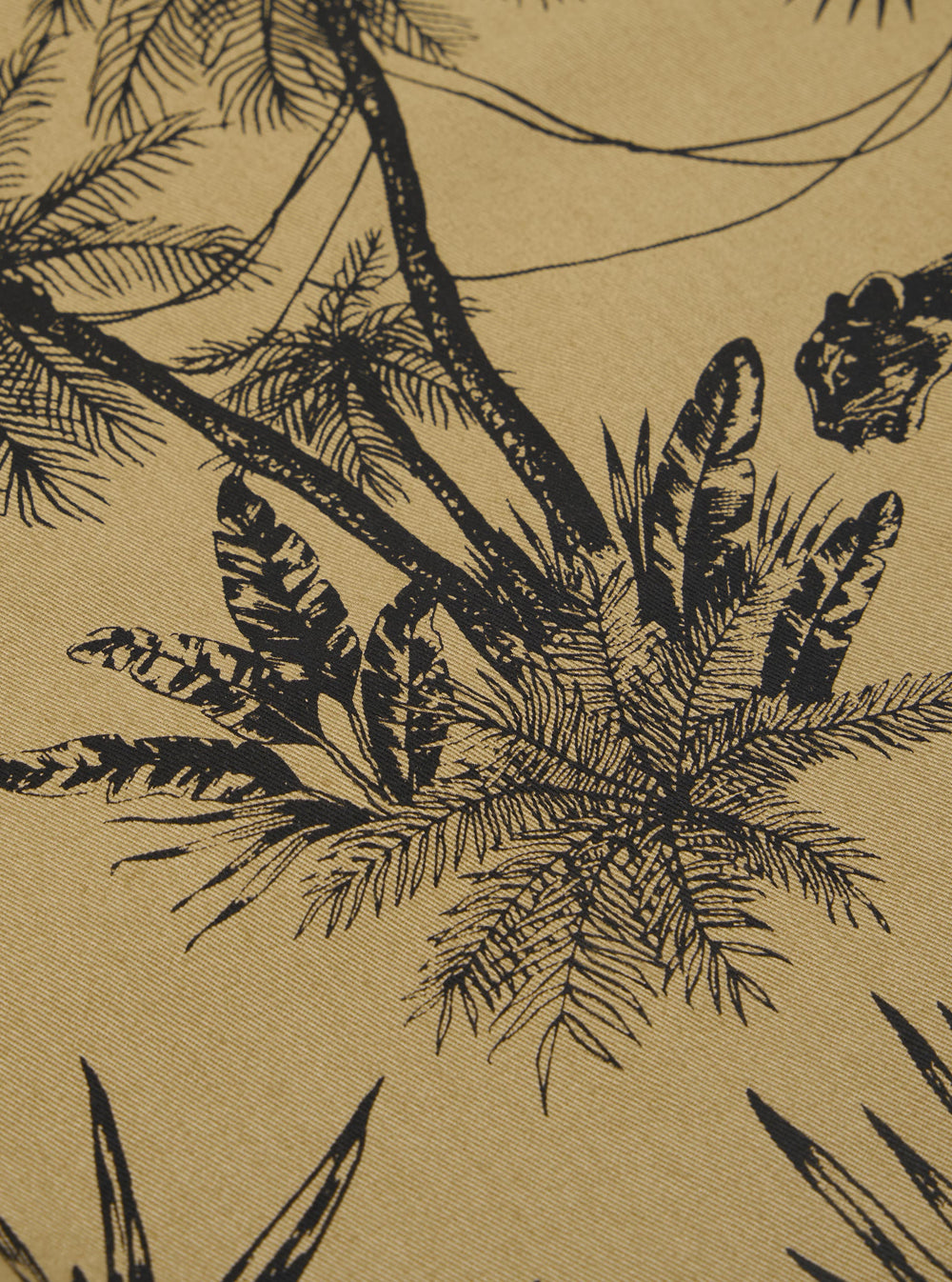 A close-up swatch image of the Sand Jungle Toile Twill Oxford Pant fabric highlights the intricate jungle toile pattern, featuring dark botanical and animal illustrations against a light sand-colored background. The texture of the cotton twill material is visible throughout the frame.