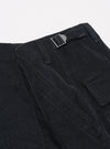 The Black Organic Fine Cord Fatigue Short is shown from the back as a flat lay against a plain white background. The image highlights the two rear patch pockets, one of which features a button-through closure, and the elasticated waistband. The black organic cotton fabric has a visible fine-wale corduroy texture.