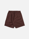 The Brown Peached Poplin Pleated Track Short is shown as a flat lay against a plain white background. The shorts feature an elasticated waistband, a single pleat on each leg, and two large patch pockets on the front. The brown cotton poplin fabric has a smooth, matte finish.